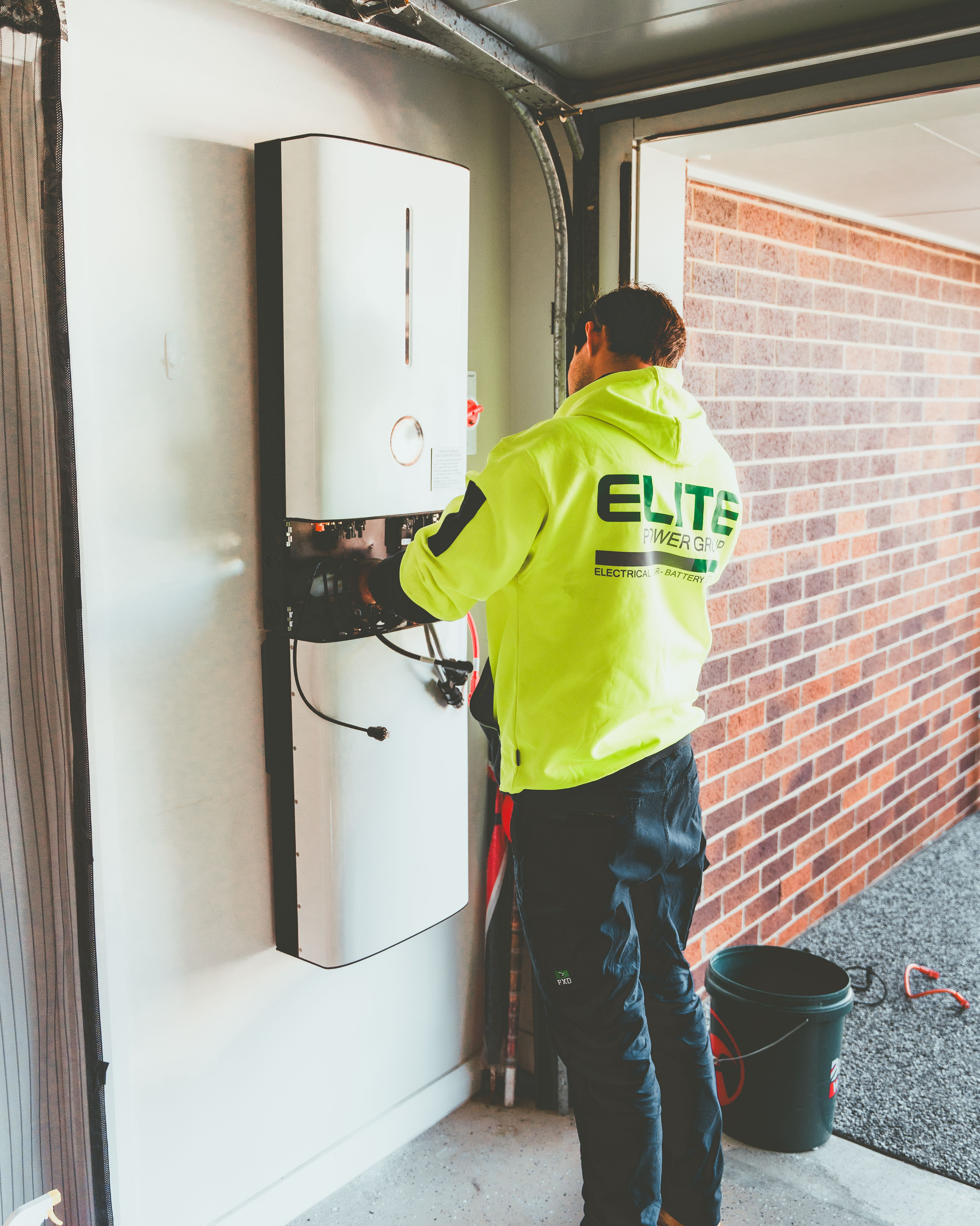 A man installing a battery storage system